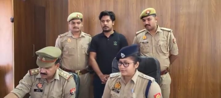 Police officers in Bulandshahr present a suspect arrested for creating fake Aadhaar cards during a press briefing.